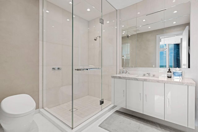 bathroom with vanity, tile patterned floors, a shower with door, and toilet