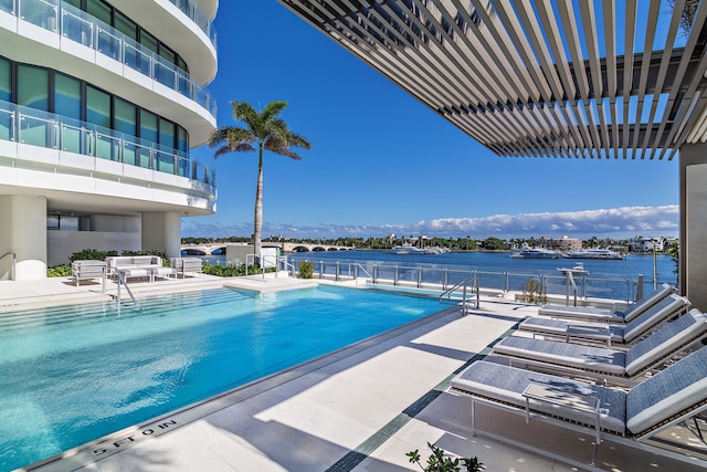 view of swimming pool with a water view and a patio