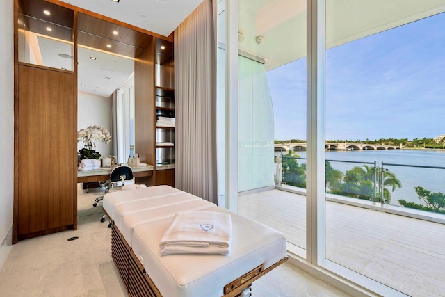 bathroom featuring a wealth of natural light, expansive windows, and a water view