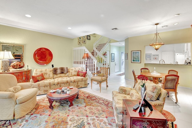 tiled living room with a notable chandelier