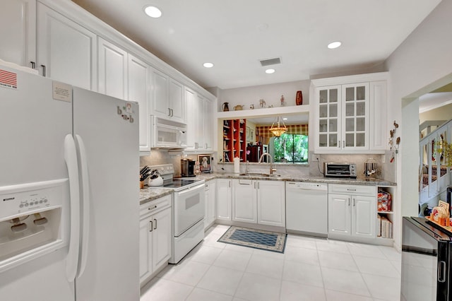 kitchen with backsplash, white cabinetry, sink, light stone counters, and white appliances