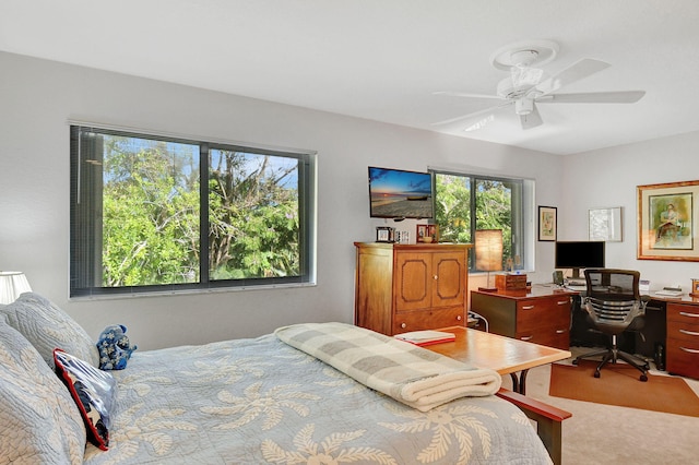 carpeted bedroom featuring multiple windows and ceiling fan