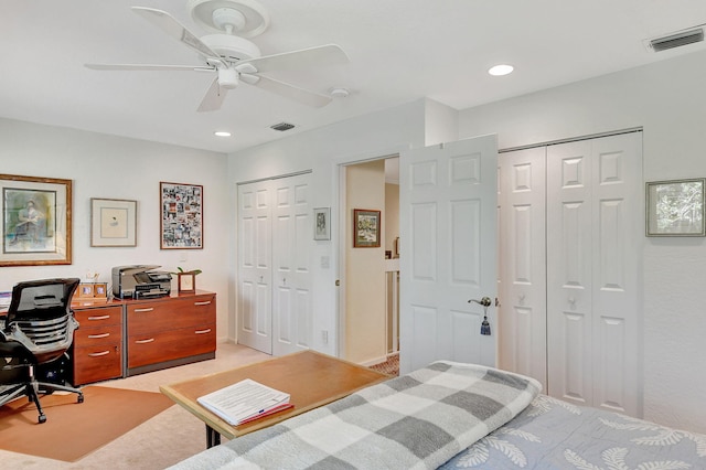 bedroom with ceiling fan and multiple closets