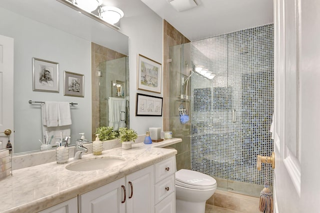 bathroom with a shower with door, vanity, toilet, and tile patterned flooring