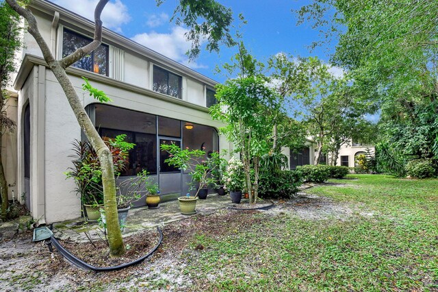 6366 Longboat Ln Unit G104, Boca Raton, FL 33433 - view of front of home with stucco siding, a sunroom, and a front yard