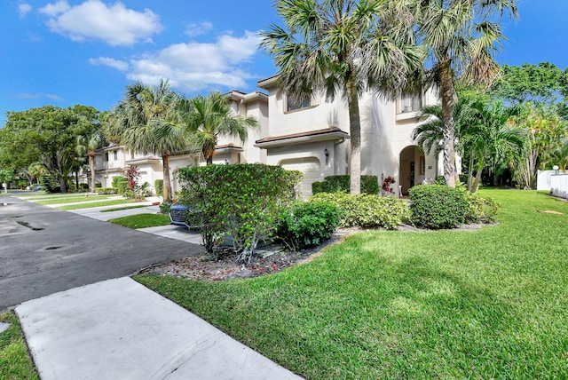 view of front of house with a garage and a front lawn