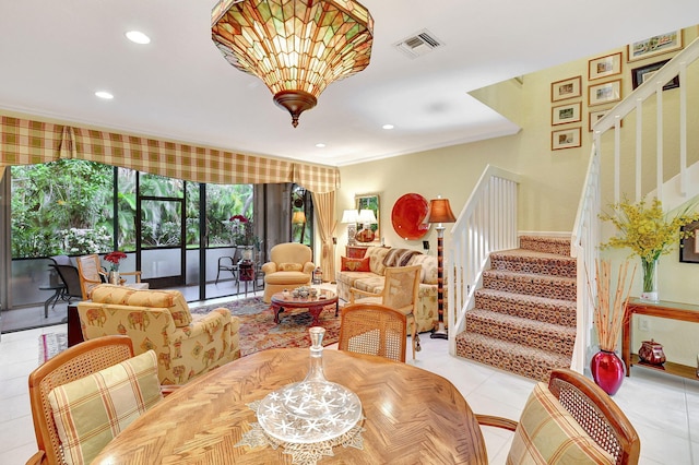 dining space with a notable chandelier, ornamental molding, and light tile patterned floors