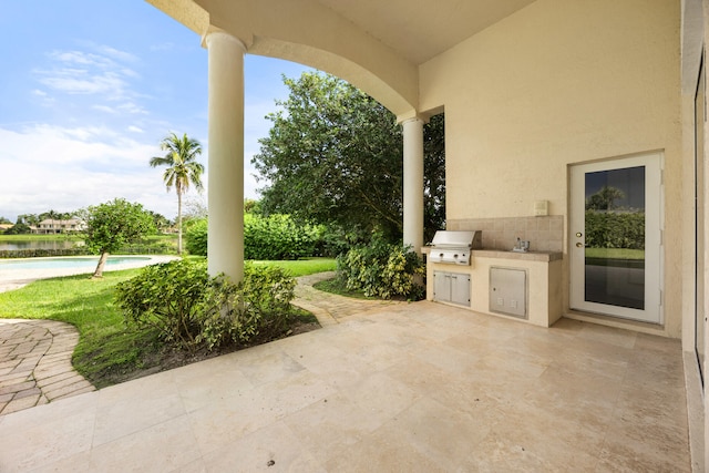 view of patio / terrace with area for grilling and a water view