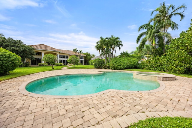 view of swimming pool with a yard, an in ground hot tub, and a patio