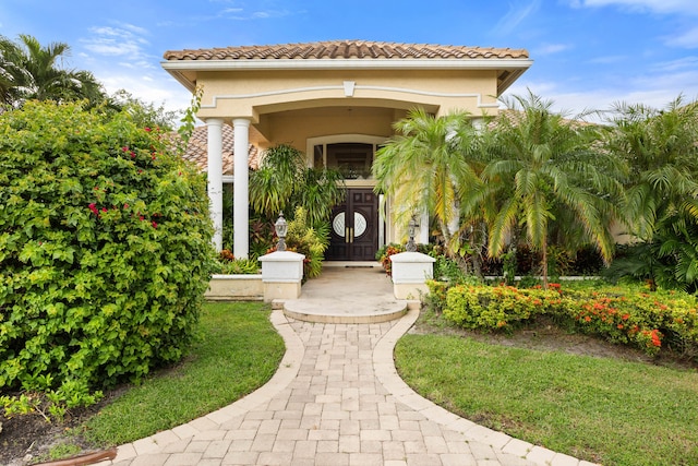 doorway to property featuring a lawn