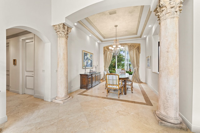 dining area featuring a raised ceiling, decorative columns, and ornamental molding