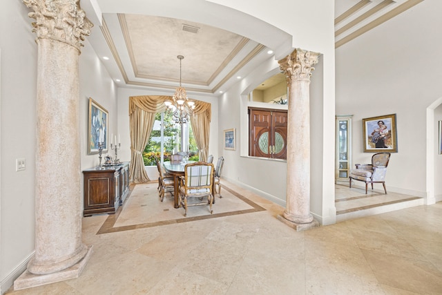 dining area with an inviting chandelier, crown molding, a raised ceiling, and decorative columns