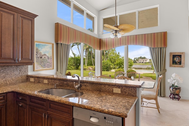 kitchen featuring sink, stone countertops, pendant lighting, stainless steel dishwasher, and decorative backsplash