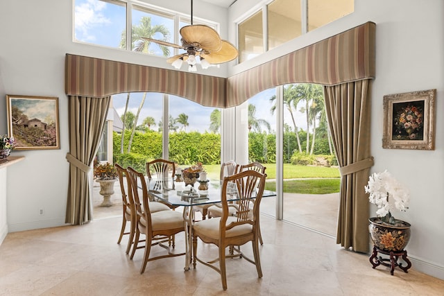 dining space with a high ceiling and ceiling fan