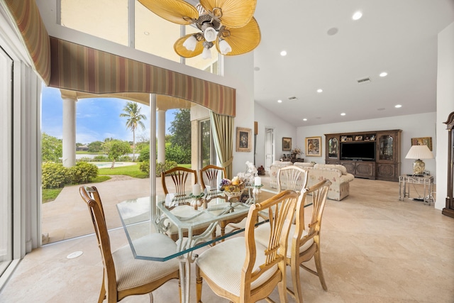 dining area with a high ceiling and ceiling fan