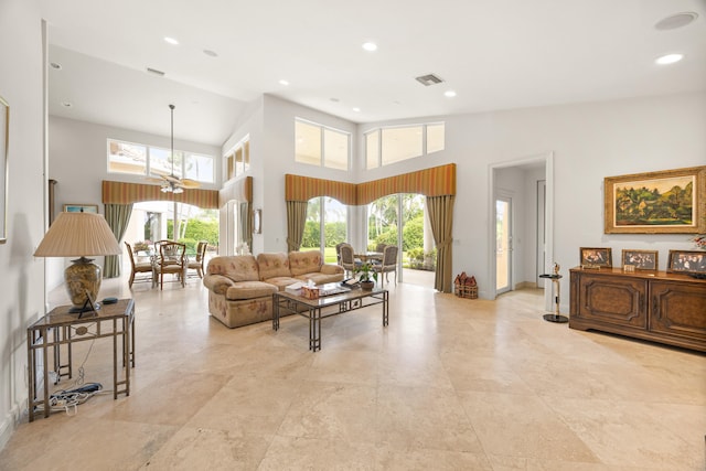 living room with a high ceiling and ceiling fan