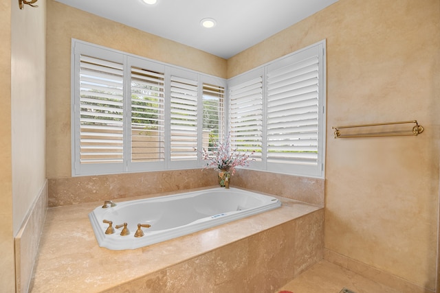 bathroom with a relaxing tiled tub