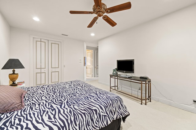 bedroom featuring light carpet, a closet, and ceiling fan