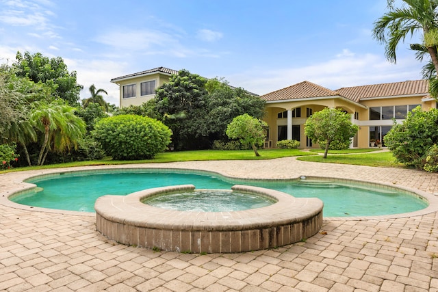 view of swimming pool with an in ground hot tub, a patio, and a yard