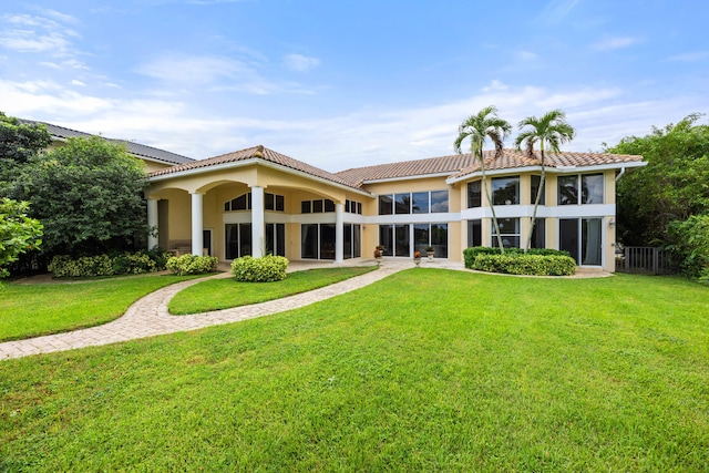 rear view of property featuring a lawn