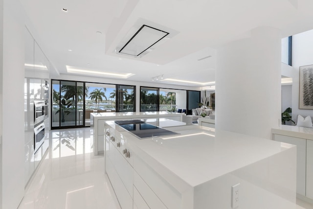 kitchen featuring white cabinetry, oven, black electric cooktop, and a large island