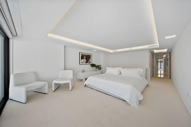 bedroom featuring a tray ceiling and light colored carpet