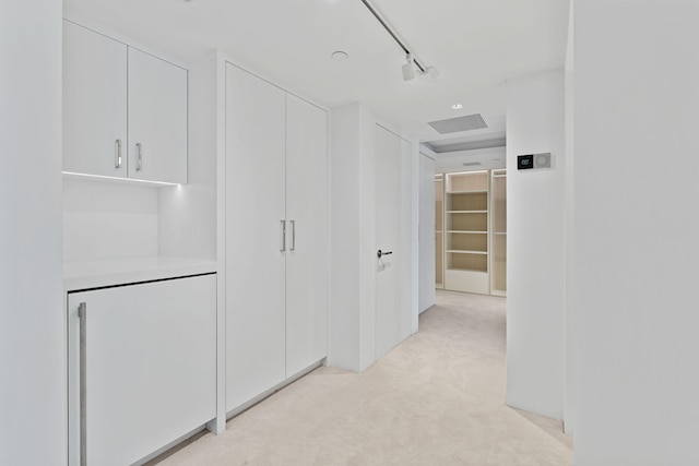 hall with light colored carpet and rail lighting