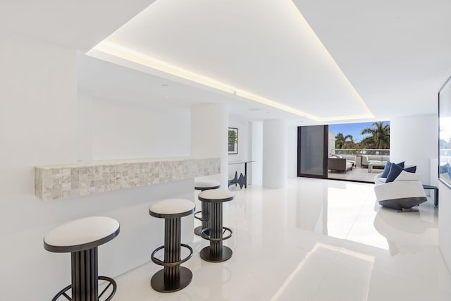 interior space featuring light tile patterned flooring and indoor bar