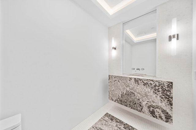 bathroom featuring tile patterned floors, toilet, and a raised ceiling