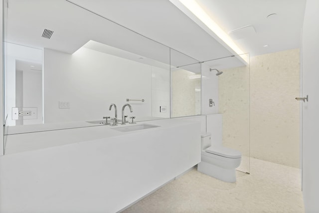 bathroom with vanity, tiled shower, and toilet