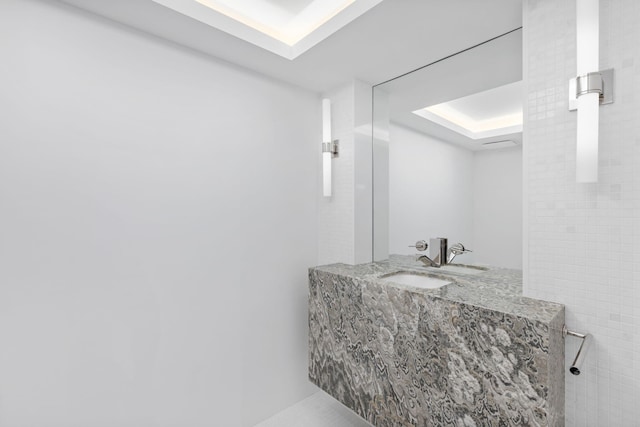 bathroom featuring sink and a tray ceiling