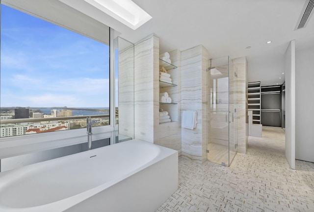 bathroom with a water view, a healthy amount of sunlight, and separate shower and tub