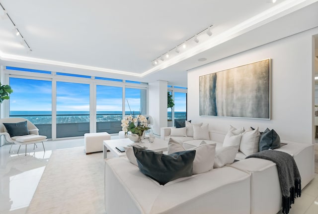 living room featuring track lighting, a water view, and light tile patterned floors