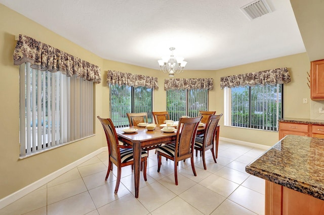 dining room with light tile patterned flooring, a healthy amount of sunlight, and a notable chandelier