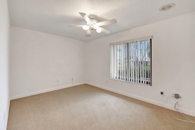 empty room featuring ceiling fan and carpet