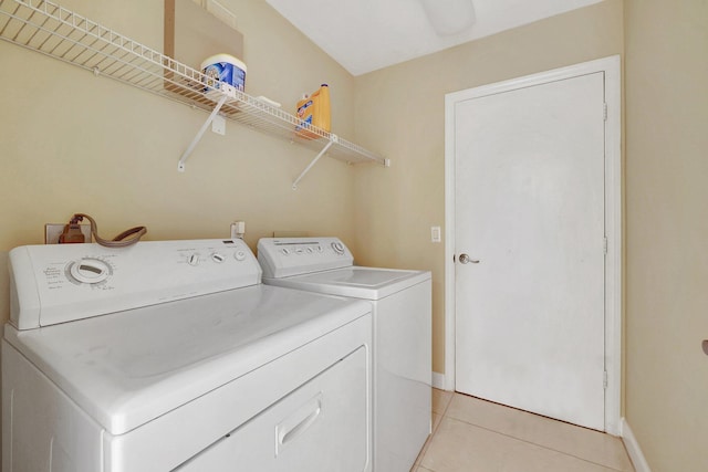 clothes washing area featuring light tile patterned flooring and washer and clothes dryer