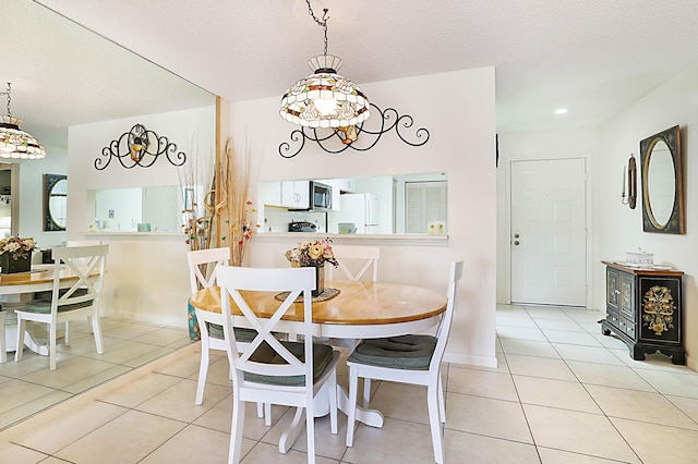 dining room with light tile patterned floors and a textured ceiling