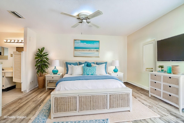 bedroom featuring ensuite bath, light hardwood / wood-style floors, and ceiling fan