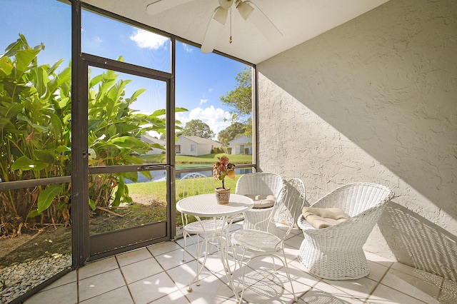 unfurnished sunroom featuring a water view and ceiling fan