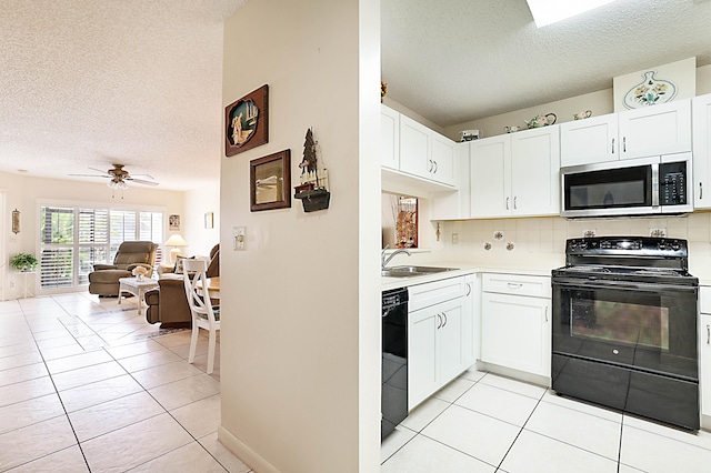 kitchen with white cabinetry, light tile patterned flooring, sink, and black appliances