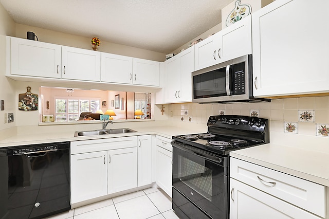 kitchen with sink, light tile patterned floors, white cabinets, and black appliances