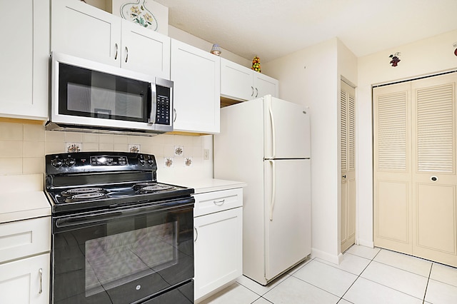 kitchen with white fridge, black range with electric stovetop, decorative backsplash, and white cabinets