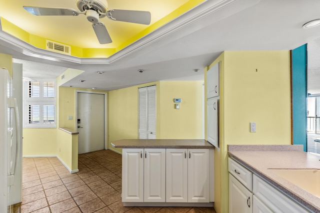 9500 S Ocean Dr Unit 1909, Jensen Beach, FL 34957 - kitchen featuring freestanding refrigerator, white cabinets, a ceiling fan, and a peninsula