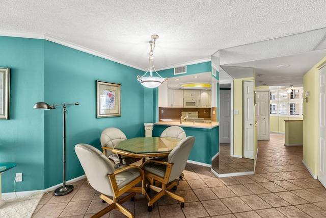 dining room featuring ornamental molding, a textured ceiling, and light tile patterned floors