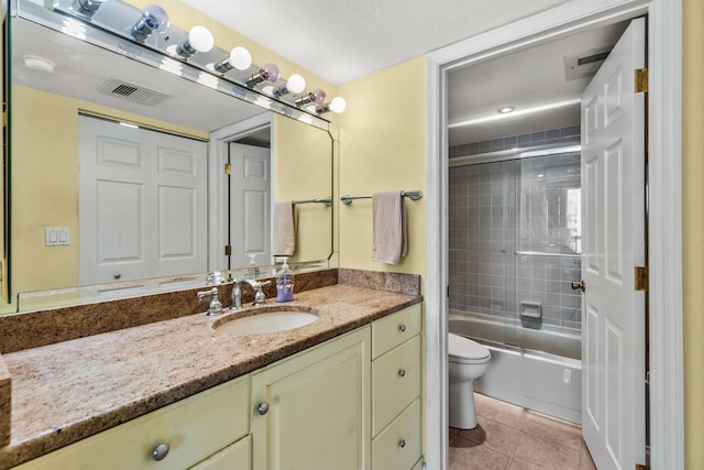 full bathroom with vanity, shower / bath combination with glass door, toilet, and tile patterned flooring