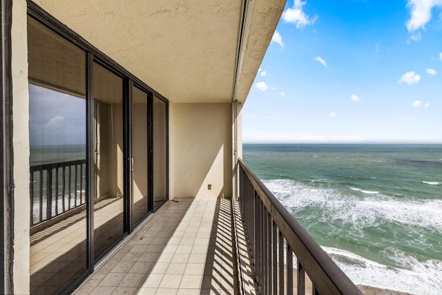 balcony featuring a water view and a beach view