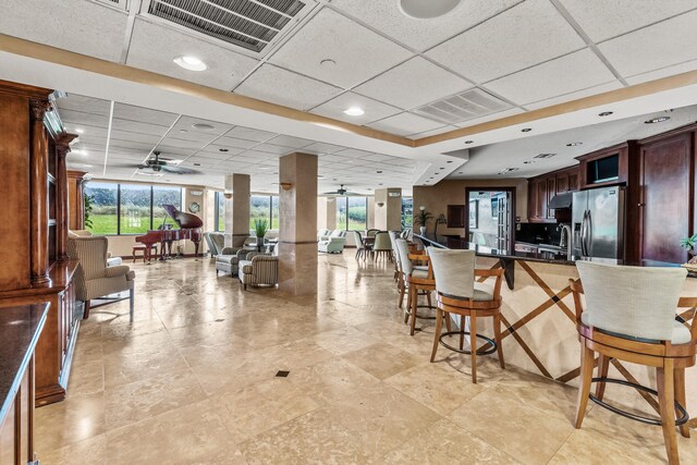 9500 S Ocean Dr Unit 1909, Jensen Beach, FL 34957 - kitchen with stainless steel fridge with ice dispenser, a breakfast bar area, ceiling fan, dark countertops, and a drop ceiling