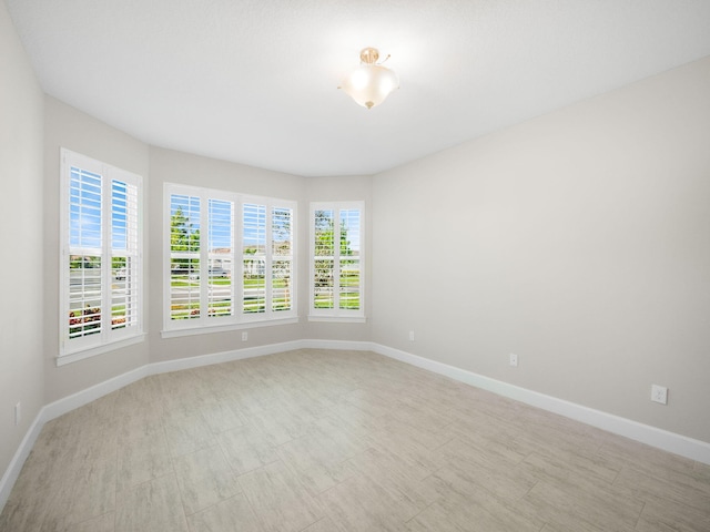 spare room featuring a tray ceiling and an inviting chandelier