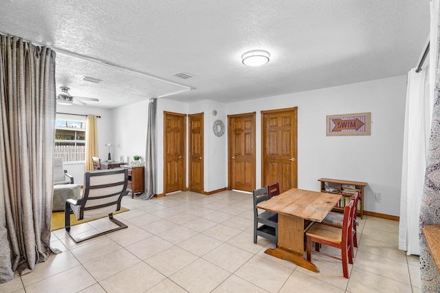 tiled dining area featuring a textured ceiling and ceiling fan