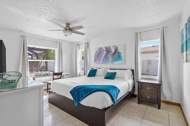 bedroom featuring a textured ceiling, light tile patterned floors, and ceiling fan